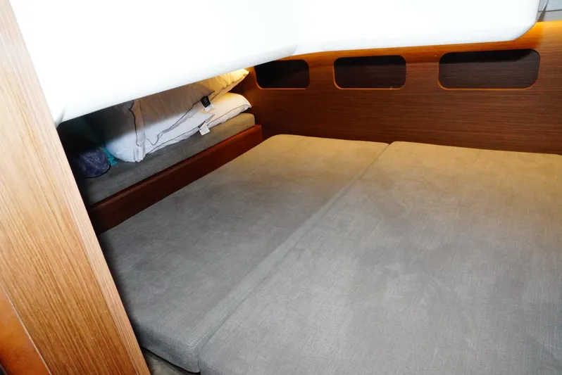 Boondoggle Yacht Photos Pics 2022 Beneteau Antares 11 cabin interior with cozy bedding and wooden accents.