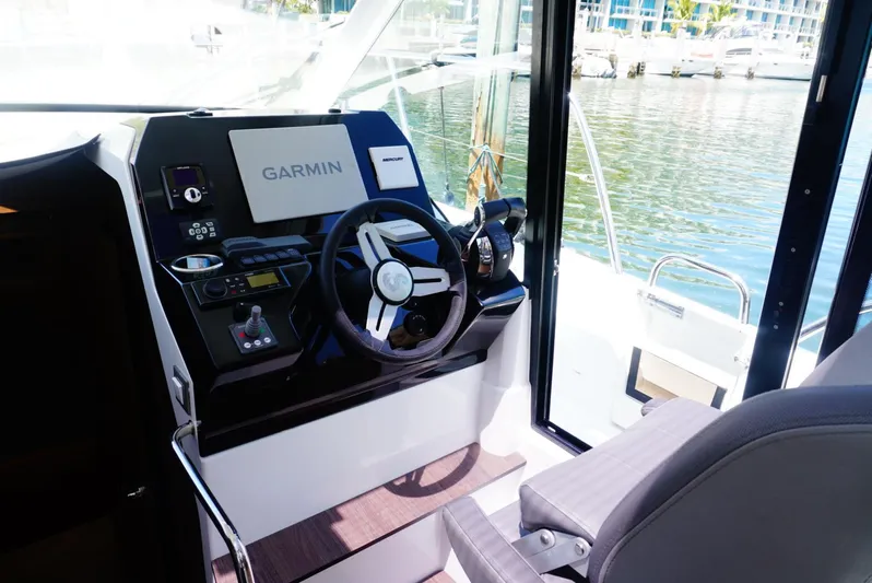 Boondoggle Yacht Photos Pics 2022 Beneteau Antares 11 helm with Garmin navigation system, docked by the water.