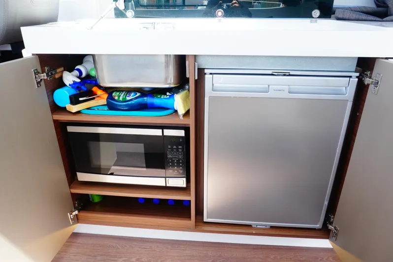 Boondoggle Yacht Photos Pics 2022 Beneteau Antares 11 kitchen with microwave, fridge, and storage.