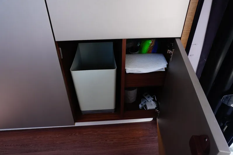 Boondoggle Yacht Photos Pics Interior storage space on 2022 Beneteau Antares 11 boat, featuring organized compartments and a waste bin.