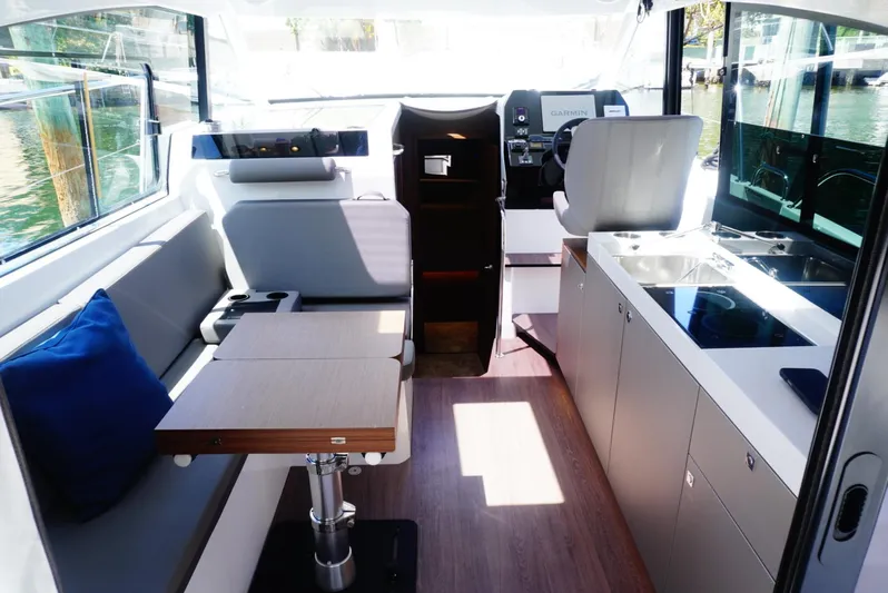 Boondoggle Yacht Photos Pics Interior of 2022 Beneteau Antares 11, featuring seating, table, and modern kitchen area.