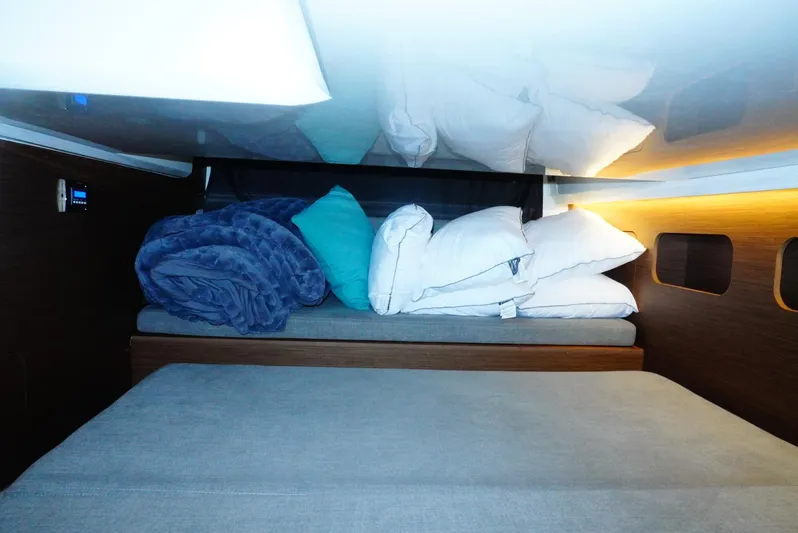 Boondoggle Yacht Photos Pics Cozy cabin interior of 2022 Beneteau Antares 11 with pillows and blankets.
