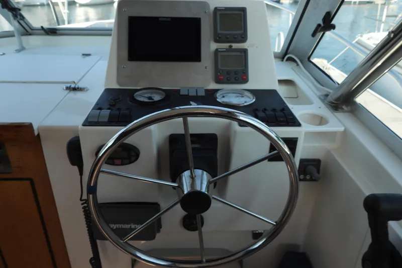  Yacht Photos Pics Helm of 2005 Back Cove 29 boat with steering wheel and navigation instruments.