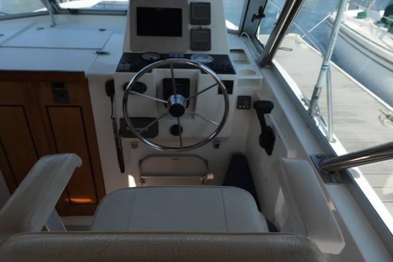  Yacht Photos Pics Helm of 2005 Back Cove 29 boat with steering wheel and navigation controls.