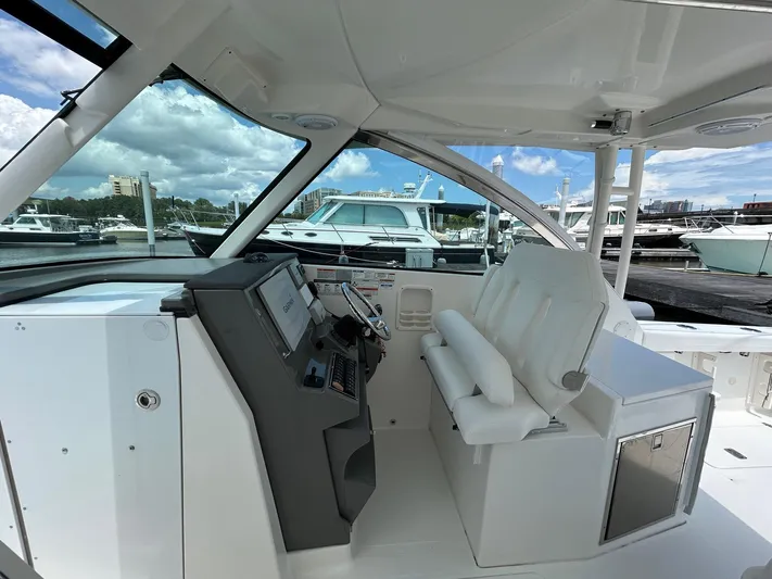 Yacht Photos Pics 2015 Pursuit DC 325 Dual Console boat interior with helm and seating at marina.