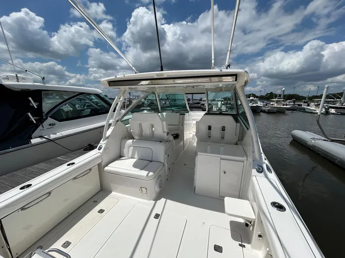  Yacht Photos Pics 2015 Pursuit DC 325 Dual Console boat docked under a partly cloudy sky.
