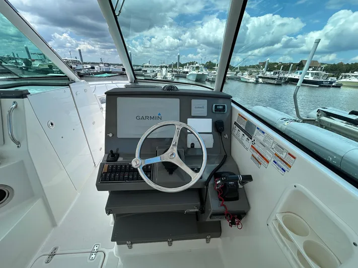  Yacht Photos Pics 2015 Pursuit DC 325 Dual Console boat helm with Garmin navigation, docked at marina.