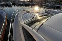 2007 Pershing 50 yacht docked at marina during sunset, reflecting sunlight on water.
