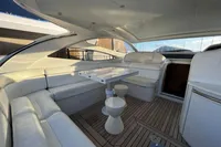 Luxurious 2007 Pershing 50 yacht interior with white seating and wooden flooring.