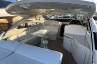 Luxurious 2007 Pershing 50 yacht interior with white seating and wooden flooring.