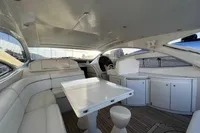 Interior of a 2007 Pershing 50 yacht with white seating and wooden flooring.
