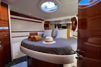 Luxurious bedroom interior of 2007 Pershing 50 yacht with round bed and skylight.
