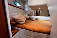 Luxurious cabin interior of a 2007 Pershing 50 yacht with cozy bedding.