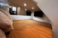 Cozy cabin interior of 2007 Pershing 50 yacht with bed and TV.