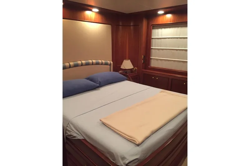 Yacht Photos Pics Luxurious bedroom interior on 1998 Sanlorenzo 82 yacht with elegant wood paneling.