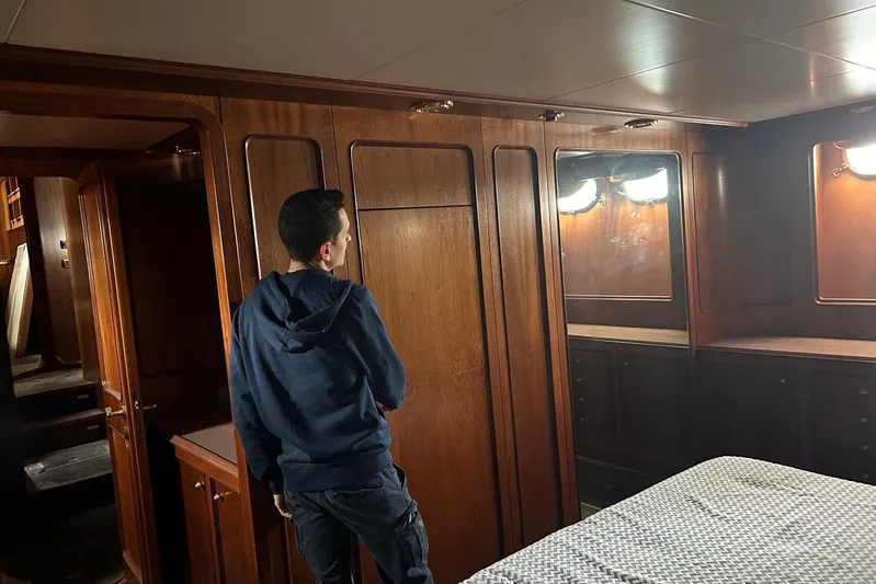  Yacht Photos Pics Man inside 1998 Sanlorenzo 82 yacht cabin with wooden interior.