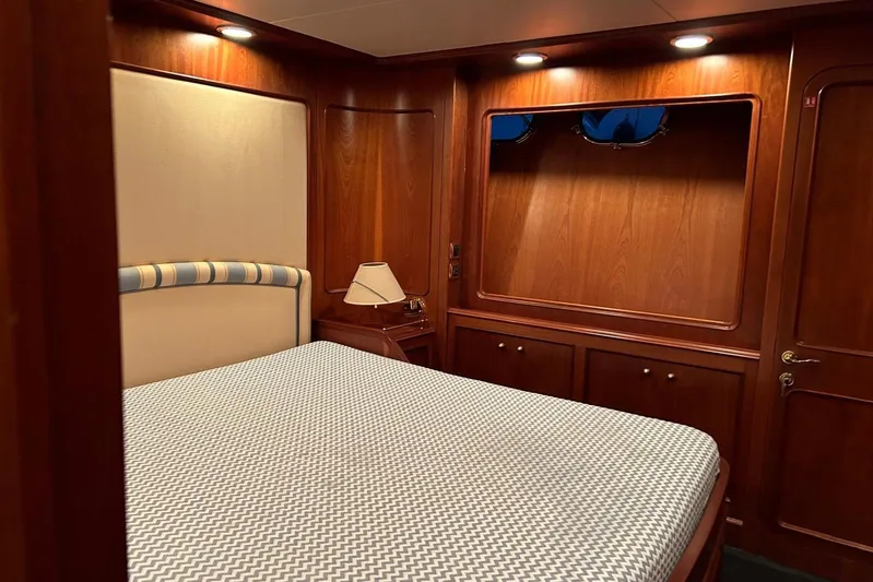  Yacht Photos Pics Luxurious cabin interior of 1998 Sanlorenzo 82 yacht with wood paneling and cozy bed.