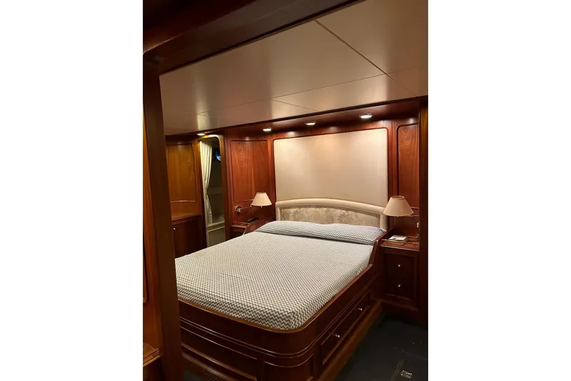  Yacht Photos Pics Luxurious bedroom interior on 1998 Sanlorenzo 82 yacht with elegant wood finish.