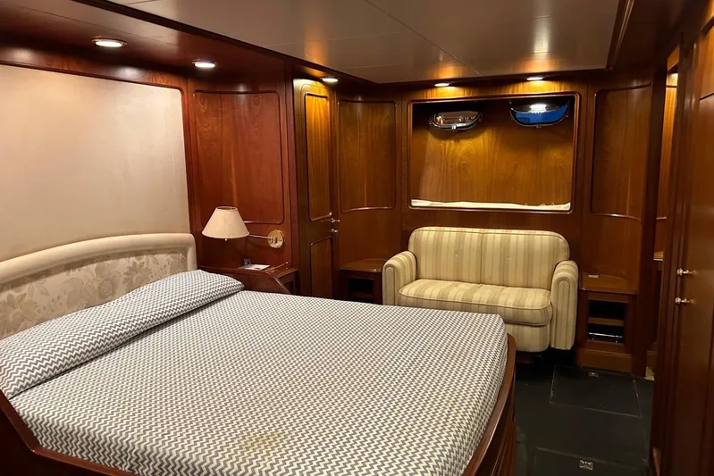  Yacht Photos Pics Luxurious cabin interior of 1998 Sanlorenzo 82 yacht with wood paneling and cozy furnishings.