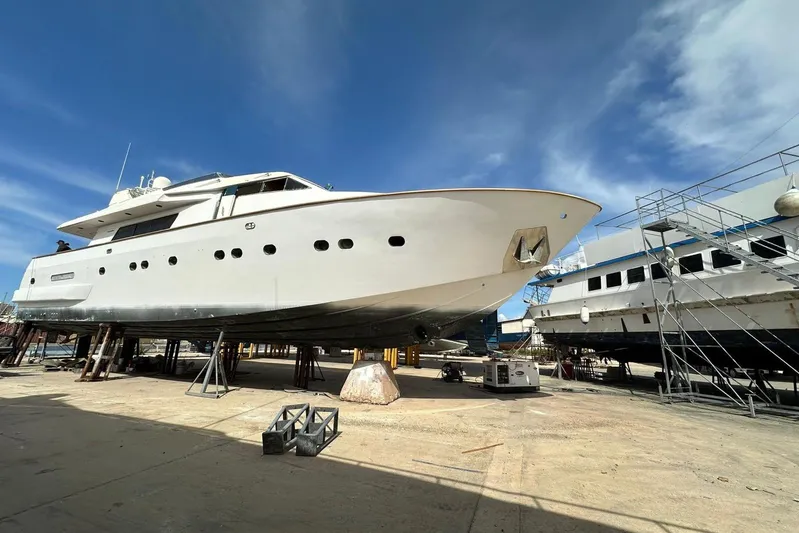  Yacht Photos Pics Sanlorenzo 82 yacht from 1998 in dry dock under a clear blue sky.