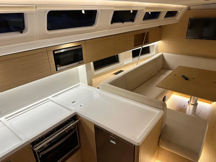 The Perch Yacht Photos Pics Modern interior of 2023 Grand Soleil 46 LC yacht with kitchen and seating area.