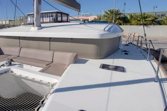  Yacht Photos Pics 2019 Lagoon 450S catamaran deck with seating and netting, docked in a marina.