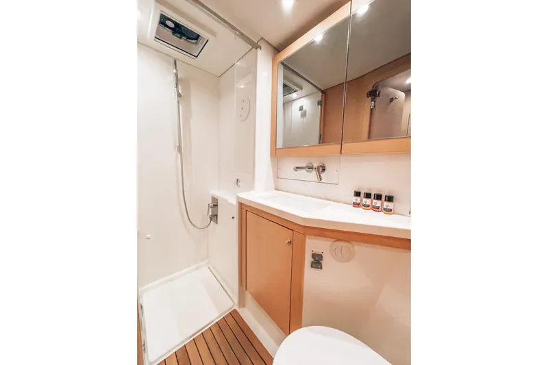  Yacht Photos Pics Luxurious bathroom in 2019 Lagoon 450S yacht with modern fixtures and wooden accents.