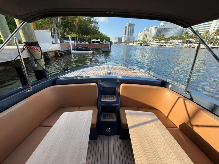  Yacht Photos Pics 2021 Frauscher 1017 GT Air boat interior with tan seating, docked in a scenic marina.