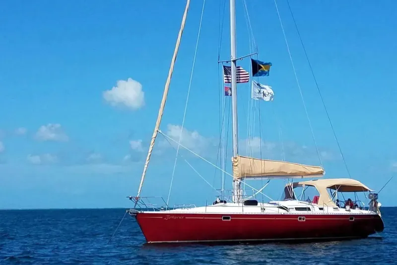 Zephyrus Yacht Photos Pics Red 1991 Beneteau Oceanis 50 sailboat on open sea under clear blue sky.