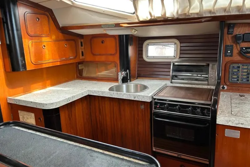Zephyrus Yacht Photos Pics Interior view of 1991 Beneteau Oceanis 50 yacht kitchen with wood cabinetry and appliances.