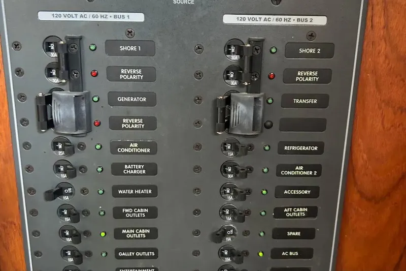 Zephyrus Yacht Photos Pics Electrical panel of a 1991 Beneteau Oceanis 50 sailboat, showing circuit breakers and switches.