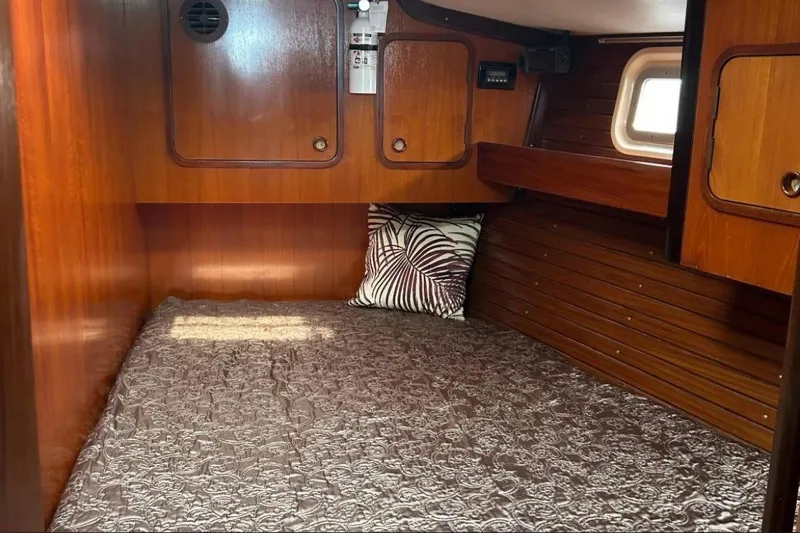 Zephyrus Yacht Photos Pics Cozy cabin interior of 1991 Beneteau Oceanis 50 sailboat with wood paneling and bedding.