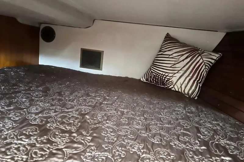 Zephyrus Yacht Photos Pics Cozy cabin interior of 1991 Beneteau Oceanis 50 with patterned bedding and decorative pillow.