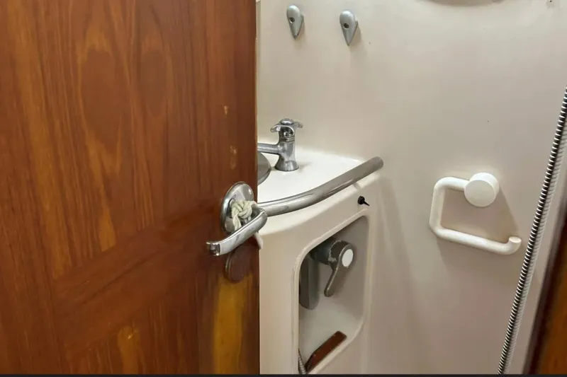 Zephyrus Yacht Photos Pics Interior of 1991 Beneteau Oceanis 50 yacht bathroom with sink and wooden door.