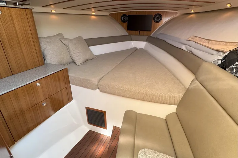  Yacht Photos Pics 2006 Pursuit LS 345 Drummond Runner cabin interior with beige seating and wooden cabinetry.