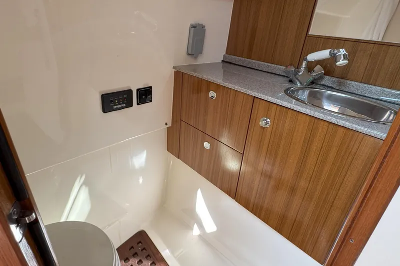  Yacht Photos Pics 2006 Pursuit LS 345 Drummond Runner boat bathroom with wood cabinets and sink.