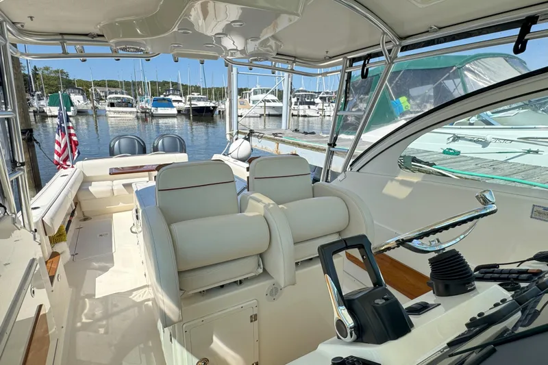  Yacht Photos Pics 2006 Pursuit LS 345 Drummond Runner boat interior at marina, featuring helm and seating.