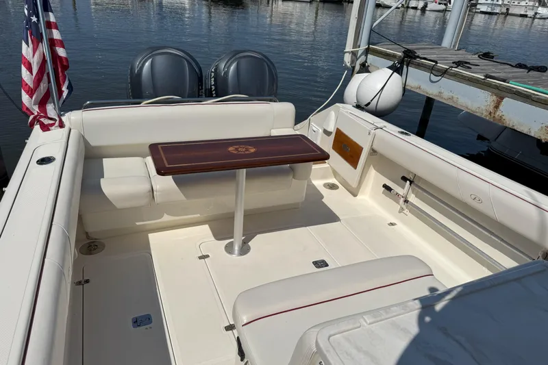  Yacht Photos Pics 2006 Pursuit LS 345 Drummond Runner boat interior with seating and table, docked by water.