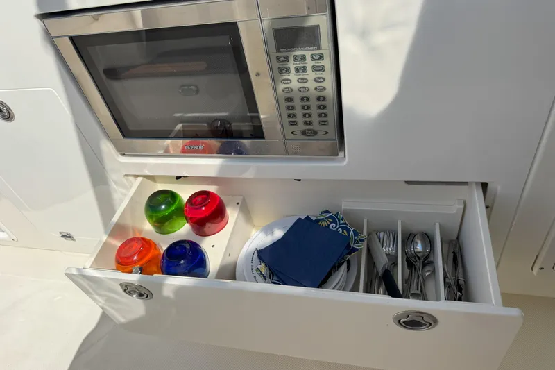  Yacht Photos Pics 2006 Pursuit LS 345 Drummond Runner kitchen with microwave, colorful bowls, and utensils.