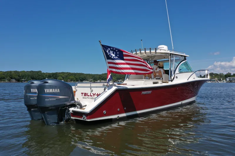  Yacht Photos Pics 2006 Pursuit LS 345 Drummond Runner boat with American flag on a sunny lake.