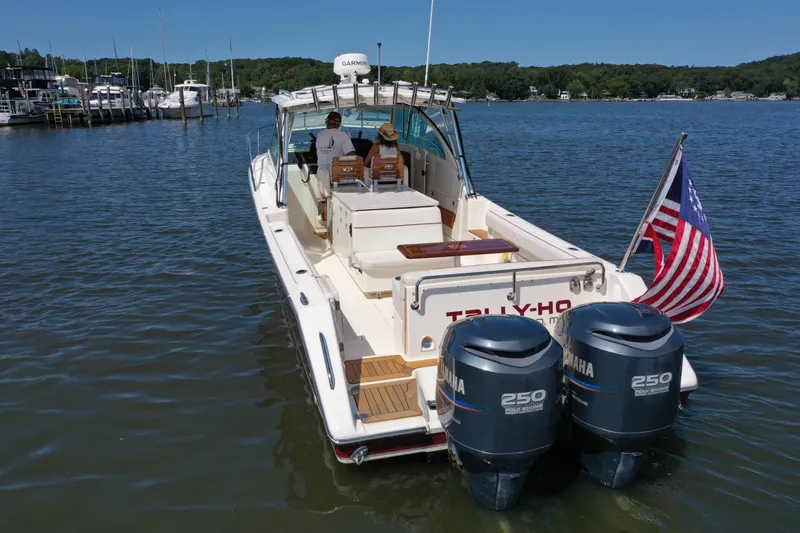  Yacht Photos Pics 2006 Pursuit LS 345 Drummond Runner boat with dual Yamaha engines on a calm lake.
