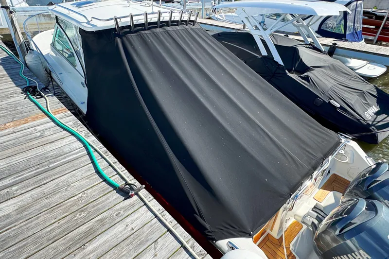  Yacht Photos Pics 2006 Pursuit LS 345 Drummond Runner boat with black cover docked at marina.