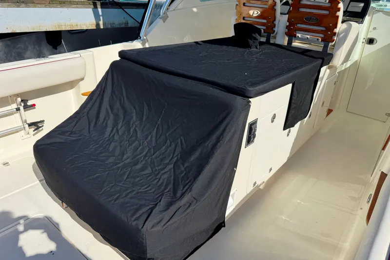  Yacht Photos Pics 2006 Pursuit LS 345 Drummond Runner interior with black covers and wooden seats.