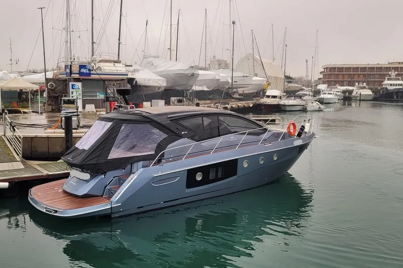  Yacht Photos Pics 2023 Cranchi M44 HT yacht docked in a marina, surrounded by other boats.