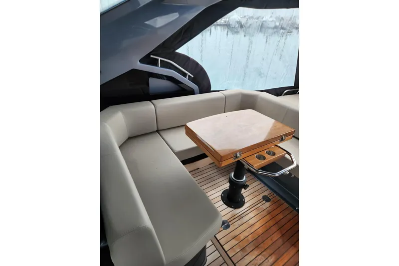  Yacht Photos Pics Luxurious seating area on 2023 Cranchi M44 HT yacht with wooden table and leather upholstery.