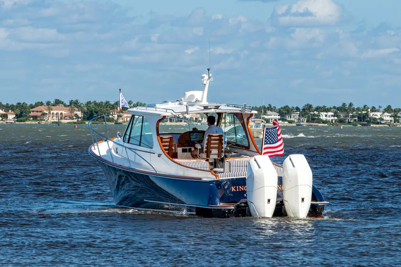King's Landing Yacht Photos Pics 2024 Hinckley 35 boat cruising on water with American flag, scenic coastal background.