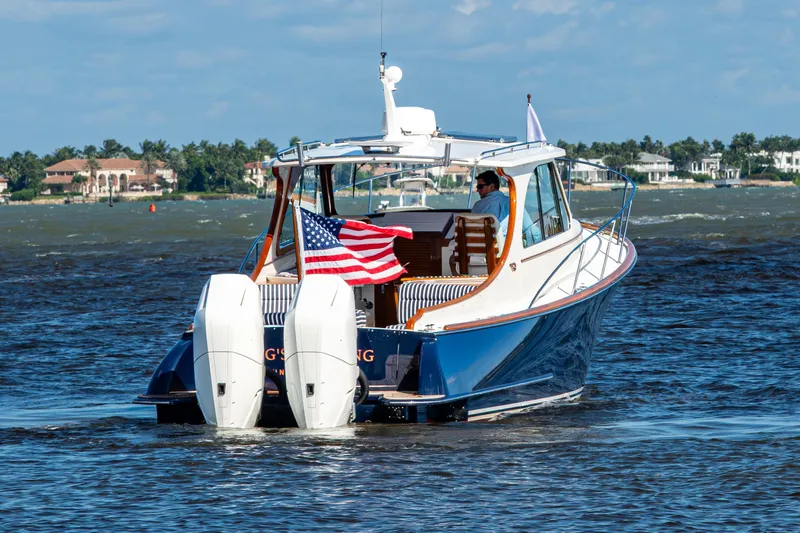 King's Landing Yacht Photos Pics 2024 Hinckley 35 boat cruising on water with American flag, sunny day.