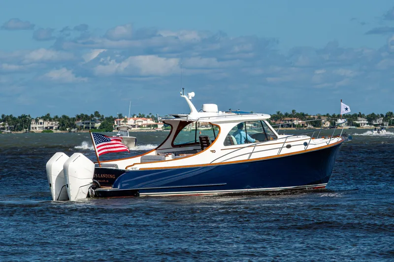 King's Landing Yacht Photos Pics 2024 Hinckley 35 boat cruising on water with American flag, clear sky background.
