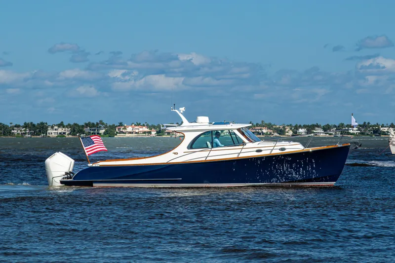 King's Landing Yacht Photos Pics 2024 Hinckley 35 yacht cruising on water with American flag, clear sky background.