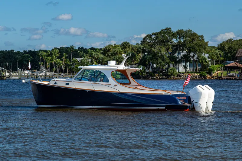 King's Landing Yacht Photos Pics 2024 Hinckley 35 boat cruising on a scenic river with lush greenery.